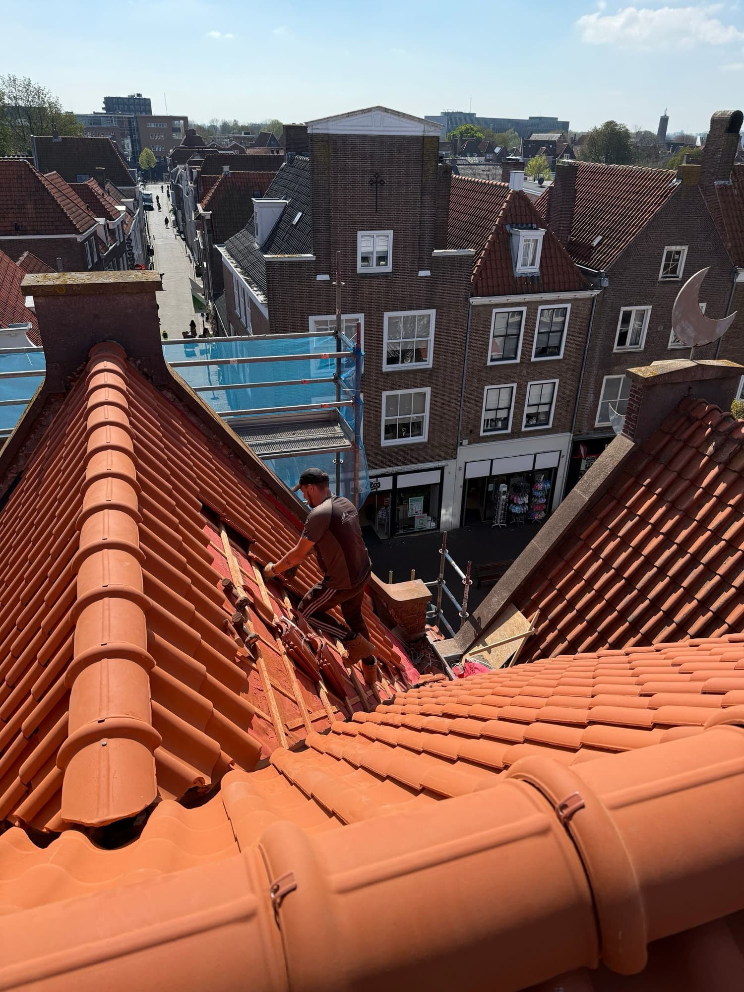 Vakman van Van Broekhoven legt een nieuw pannendak boven bovenwoningen in de binnenstad van Breda